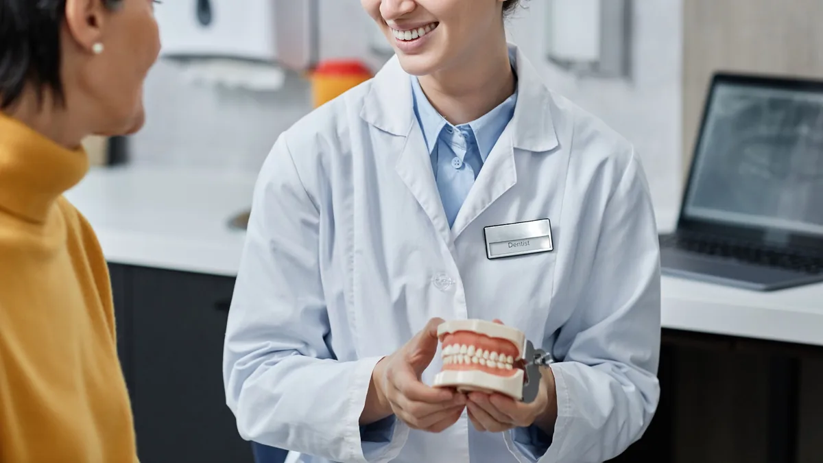 A clinician explaining a treatment plan to a patient with a model of the teeth